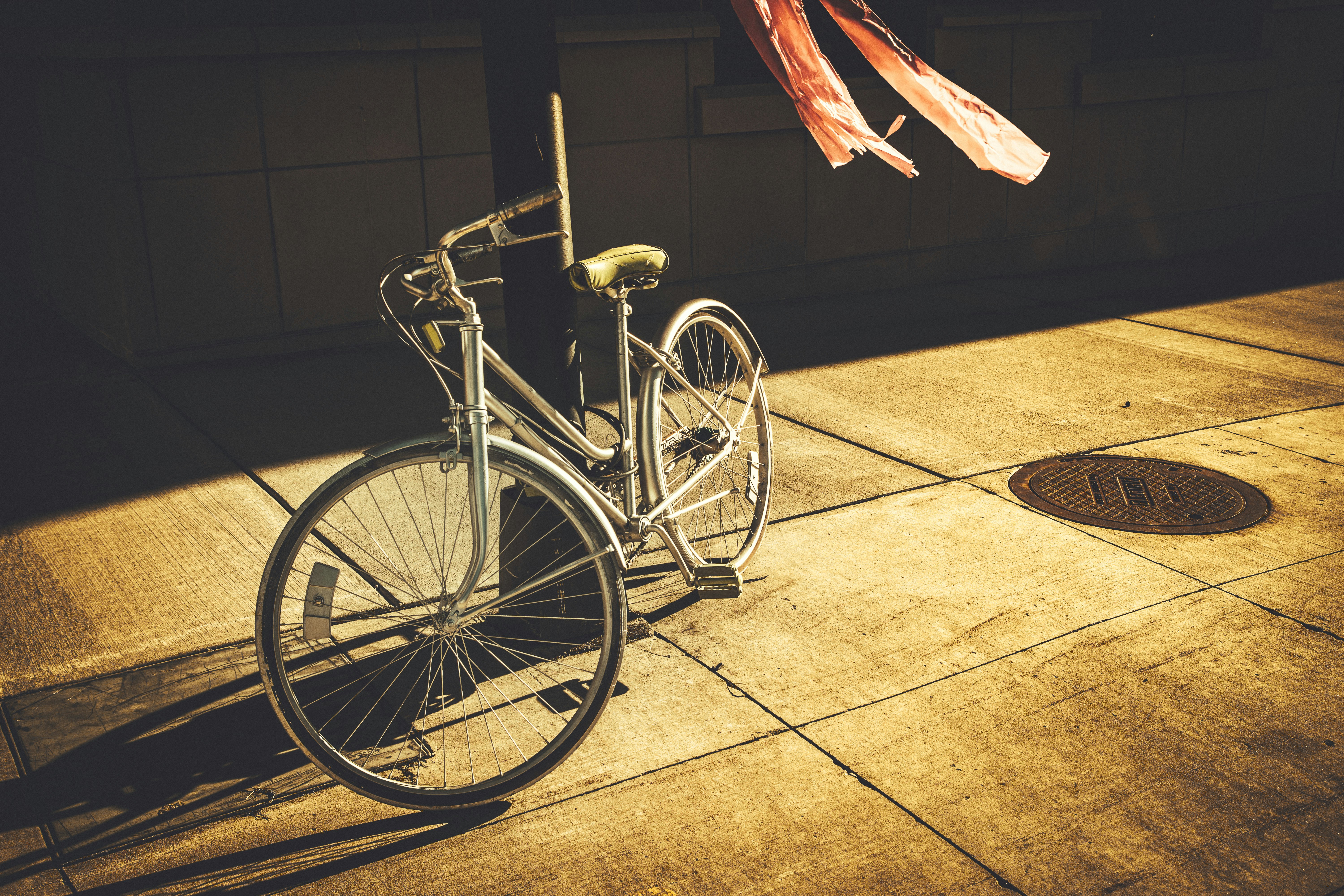 gray step-through bike leaning on black post